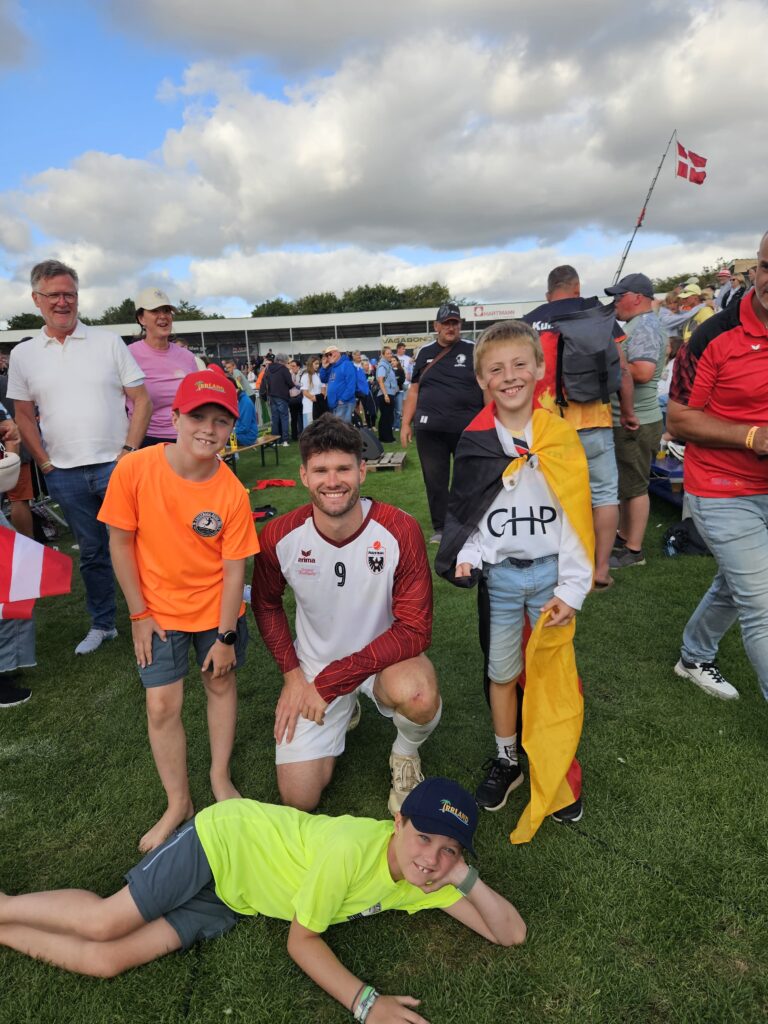 Schülper Nachwuchsfaustballer mit einem Spieler der österreichischen Nationalmannschaft bei der Faustball-EM in Tondern