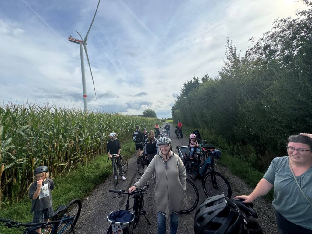 Teilnehmende der TSV-Fahrradtour mit Fahrrädern an einem Windrad
