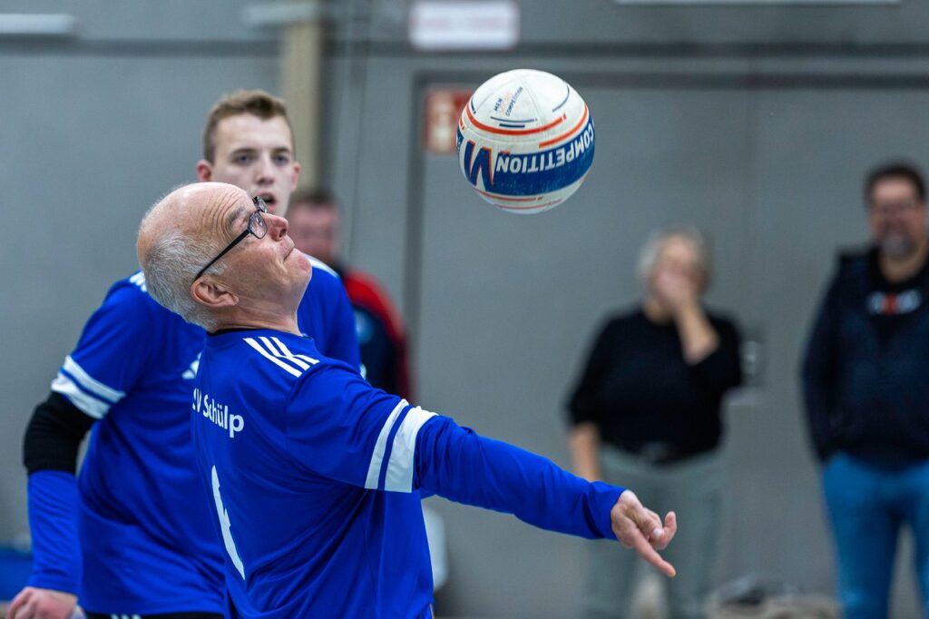Ein Schülper Faustballspieler richtet den Blick auf den Ball über ihm und streckt den Arm zum Zuspiel aus.